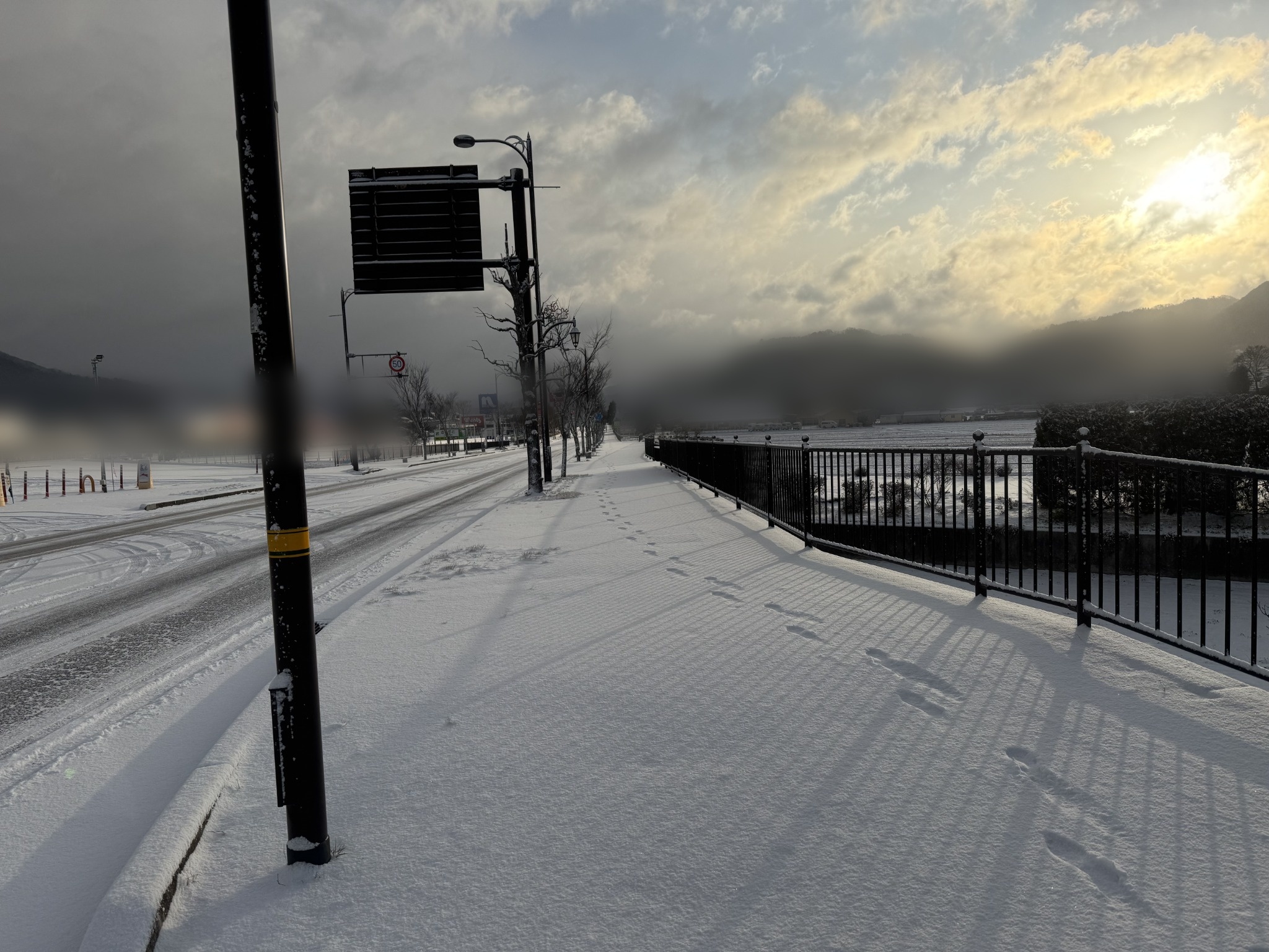 雪が積もった地方道路と山間部の風景